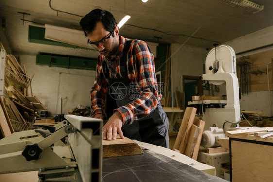 木工车间的作流程服的人在木车间使用加厚刨床专业木工和人的概念车间作流程A挖出工具图片