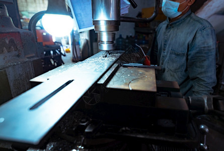 操作员工业的厂一名男子佩戴外服面具与磨机一起工作使用具水泥的碳化石磨粉厂切割金属制品垂直碾磨机加工钢铁制造业冶炼艺图片