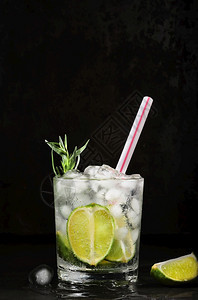垂直的重点深底垂直框架的柠檬汁杯选择焦点自制饮料包括石灰柏拉贡矿泉水和冰立方体冷新鲜柠檬水图片