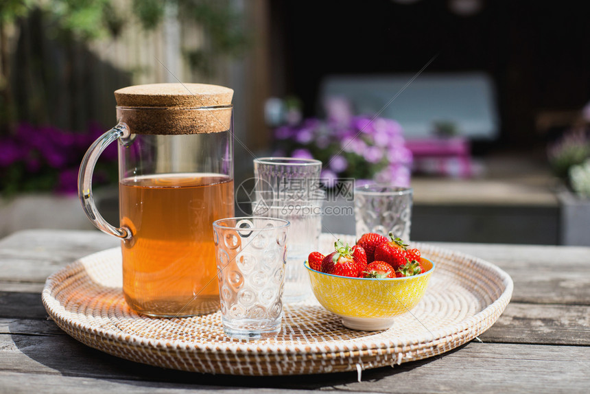 自然颜色夏季菜桌上有草莓的鲜柠檬水夏季园艺桌上有草莓的户外露天夏季有彩色鲜花的新自制柠檬水夏季有草莓模糊图片