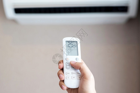 凉爽的屋人们对空调进行遥控制25摄氏度以节省室内的电量技术图片