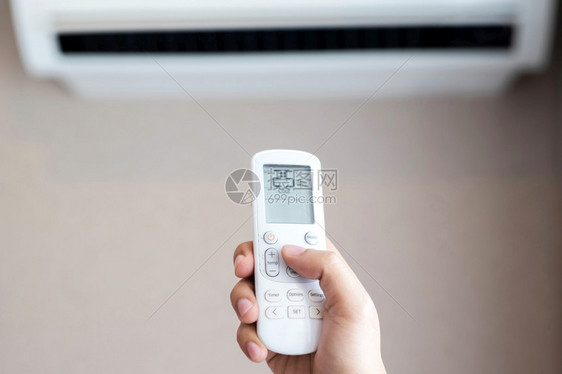 凉爽的屋人们对空调进行遥控制25摄氏度以节省室内的电量技术图片
