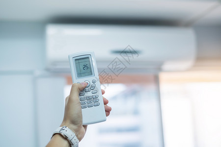 力量按钮自在办公室或房屋内空调机使用手动遥控器调节办公室或房屋内的空调机图片