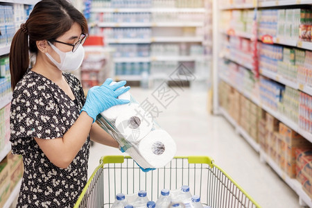 市场买亚洲人妇女在超市或杂货店购物时佩戴保护面具和持有卫生纸的亚洲妇女保护阴锥体渗透卫生新正常和19次大流行后的生活图片