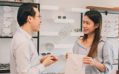 亚洲男眼科医生在光学和销售促概念商店向女顾客提供咨询或并向她们出售眼镜亚洲男科医生在光学和销售促进概念商店向女顾客提供建议或咨询图片