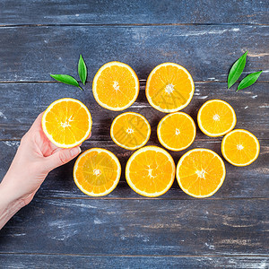 可口棕色的素食主义者有创意的黑暗风格平板最顶端是新鲜橙子水果切片女手放在棕色木桌背景上复制空间最小夏季新鲜柑橘成分用于博客或食谱图片