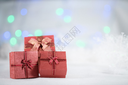包裹Bokoh背景的白皮上红色礼物盒并有圣诞快乐或新年节季喜悦或新年点选择的复制空间blurred毛皮蓝色的图片