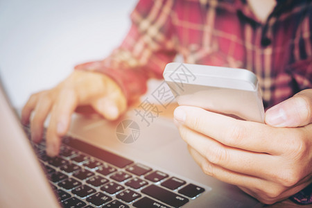 银行业联系打字手持智能机和信用卡的人在网上银行购物络做买卖图片