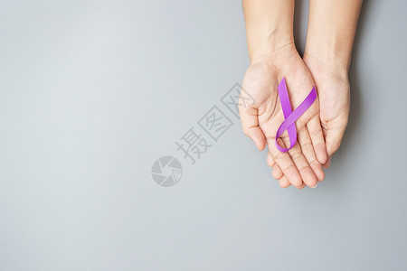 手拿紫色丝带预防癌症概念图片