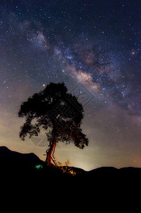 螺旋银河系与宇宙中的星和太空尘埃夜上的黄道带光在山景上的树云移动PhuSawan水库Phetchaburi山景深的夜晚图片