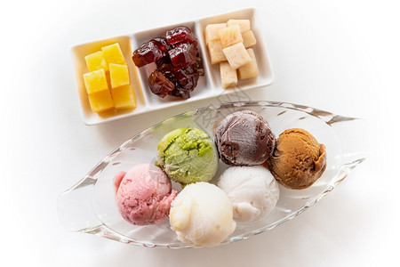 牛奶白色桌边背景上不同颜色的多彩冰淇淋夹在一张明亮的菜盘中甜美加工水果用于以泰国古老风格共进餐花彩鲜艳的雪淇淋杂冰碗香草图片