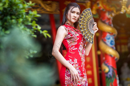 可爱的为了亚洲年轻女子身着传统红青山装饰在泰国华神庙举办中新年节盛会的风向节日活动校对Portnoy微笑图片