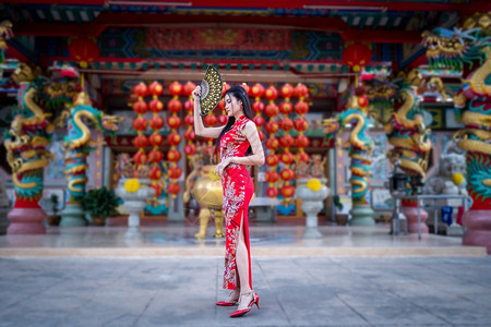 亚洲年轻女子身着传统红青山装饰在泰国华神庙举办中新年节盛会的风向节日活动校对Portnoy年轻的服装衣图片