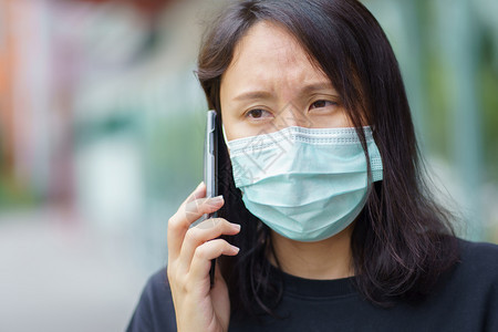 户外戴口罩打电话的妇女图片