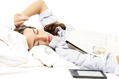 早晨女人在报纸上睡着和ebook阅读器一起除了电子书阅读器之外女人在报纸下跟ebook阅读器一起休息枕头图片