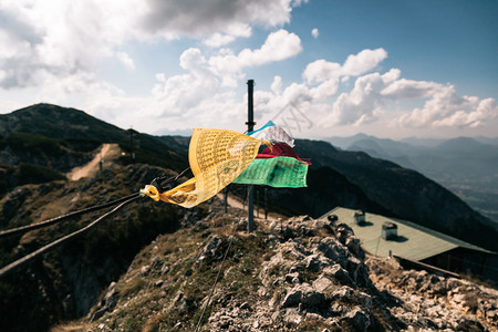 灵亚洲人风景在奥地利特斯堡山峰的风中挥舞着其背景是山地住所图片