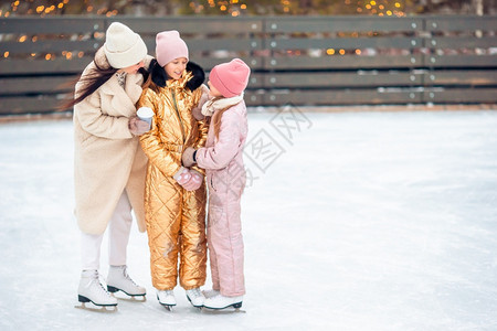 快乐的霜教学可爱小女孩和妈在溜冰场上滑家庭冬季乐趣小可爱和妈在溜冰场上图片