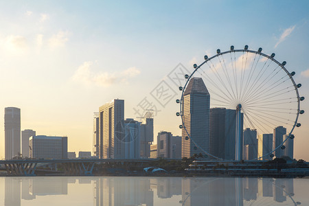 商业夜晚巨人Ferris轮和新加坡城市建筑在日落时的背景象地标图片