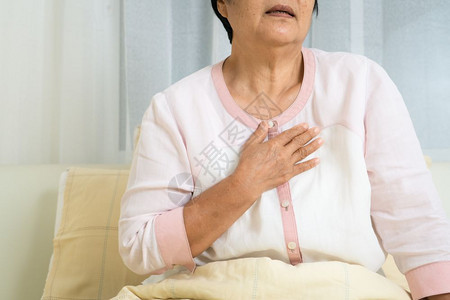 胸口感到疼痛的老年女性图片