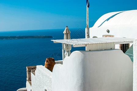 采取屋顶旅游的OiaSantorini希腊以美丽的浪漫日落闻名图片