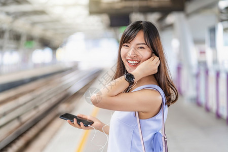 年轻亚洲女乘客地铁火车在大城市japanesechinese朝韩生活方式和日常通勤和运输概念上旅行时通过智能手机在地铁火车上偷听图片