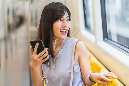 通勤者人群女士年轻亚洲乘客地铁火车在大城市japanesechinese朝韩生活方式和日常通勤和运输概念上旅行时通过智能手机在地图片