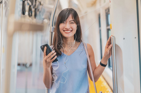 游客移动的东南年轻亚洲女乘客地铁火车在大城市japanesechinese朝韩生活方式和日常通勤和运输概念上旅行时通过智能手机在图片