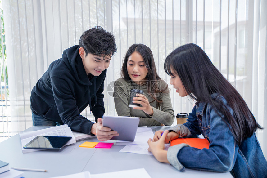 亚洲成人学生团体微笑玩乐及使用平板电脑也帮助分享工作与项目的想法并在考试前审查书本infowhatsthis药片图片