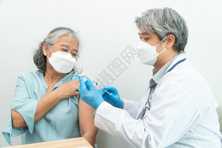 医生戴口罩为病人接种疫苗图片