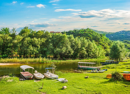 克诺耶维奇天黑山Crnojevicha河附近绿草地上的船只冷静图片