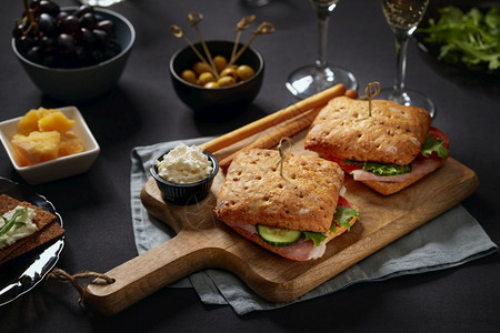经典的黑暗配有美酒三明治在切菜板和开胃起司图片