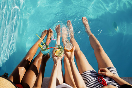 日光浴晴天团体朋友在泳池边喝饮料最佳风景是快乐人们在暑假玩得开心在泳池边户外的节日派对一个男人和两女在游泳池边晒太阳朋友在游泳池图片