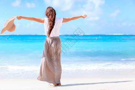苗条的海滩在白沙上快乐的年轻女子在热带海滨玩得开心的年轻美丽女子在热带海滨快乐的热带海边快乐的年轻美女在蓝色天空和西里贝图片