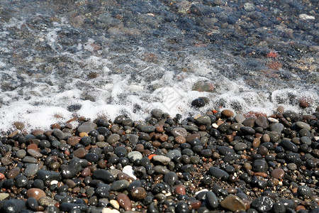 水浪漫的闲暇希腊圣托里尼岛的卡马海滩带有黑色火山石背景图片