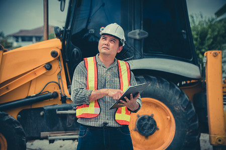 工人男人背影工人程队穿着白色安全头盔站在背影前看房屋建筑工程用