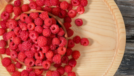收获季节在浅木本底的碗里放上多汁果莓在草汁或甜点中平铺和空间插件猩红图片