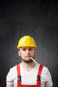 生病的建筑工人嘴里有温度计病态的建筑工人一位病态建筑工人的肖像患病疾制服图片