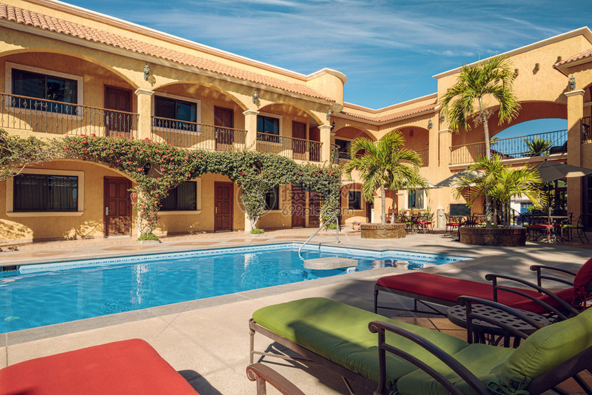 建造晴天传统的墨西哥人豪宅院子里有个绿游泳池和周围的日晒绿松石图片