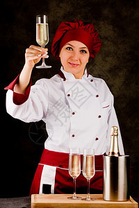 女厨师与Campagner玻璃杯的照片为健康干杯坎帕格纳制服染色图片
