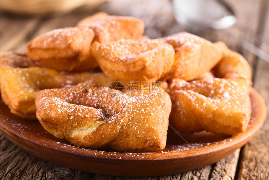 糖果智利传统的甜点烤饼卷在智利第一家甜点糕前方夹在木制板上配有糖粉的深炸馅饼中选取焦点聚于第一家智利甜点蛋糕前糖果商发酵的图片