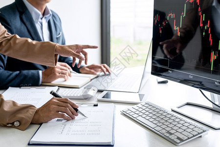 与计算机膝上型电脑讨论和分析图表股票市场交易以及股票图表数据规划金融和投资概念有关的商业小组伙伴工作包括股票图数据规划金融和投资图片