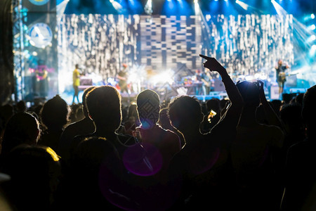 正面新的发光在音乐风扇俱部的周光中举行音乐会以展示手动作在舞台前唱歌者之后播放灯光音乐和会的概念图片
