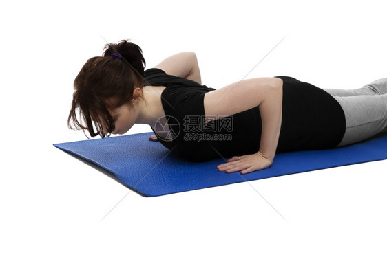 女青年在锻炼时休息在蓝色垫子上施压时休息黑发按图片