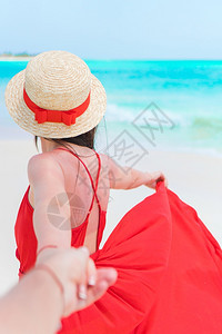潮汐白色的年轻美女在白色沙热带滩上放松年轻女士在热带海滩度假期间戴帽子年轻女士在热带海滩度假时回到快乐女孩享受节假日的景色红图片