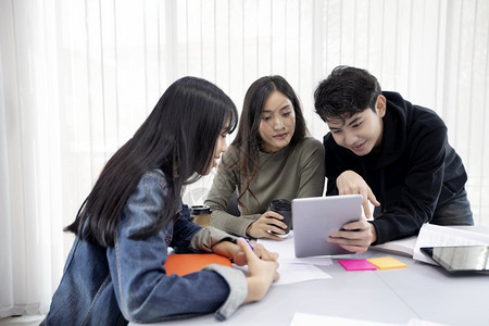 耳机亚洲商业学生团体微笑玩乐及使用平板电脑也帮助分享工作与项目的想法并在考试前审查书本infowhatsthis图片