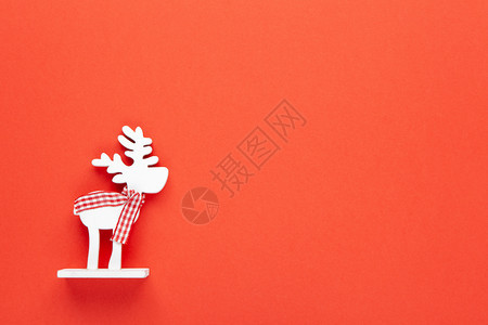 圣诞装饰玩具白色鹿在红背景的围巾上打字面印有空间节日新年概念水平地样魔法童年情绪图片