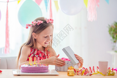食物家庭可爱的小女孩在她生日快乐和兴奋她的白种女孩在生日节喜悦色彩多的背景与气球生日派对和愿望概念图片