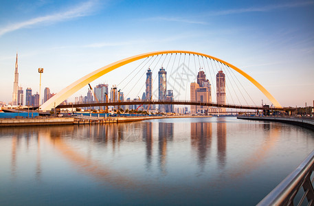 城市景观最高镇迪拜市中心摩天大楼和新建的容忍桥上从迪拜水渠中可以看出日落是多彩的图片