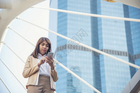 女士使用智能手机在线购物打电话发短信互联网技术生活方式的女商人使用手机在城市街道上行走智能手机自信女现代城市天信息图片