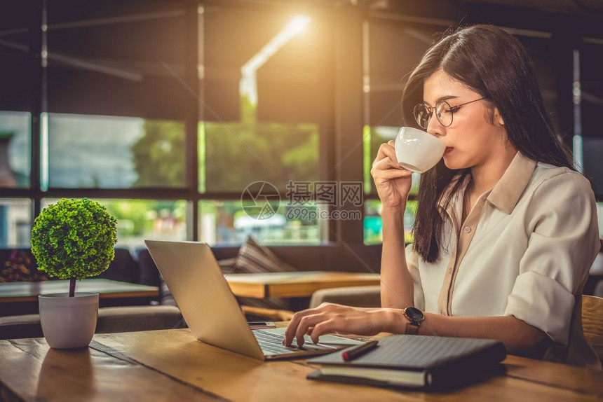 在咖啡馆使用笔记本电脑和喝咖啡的亚洲工作妇女人与生活方式概念技术和商业主题自由与职业夜间概念中的工作狂专题随意的办公室手图片